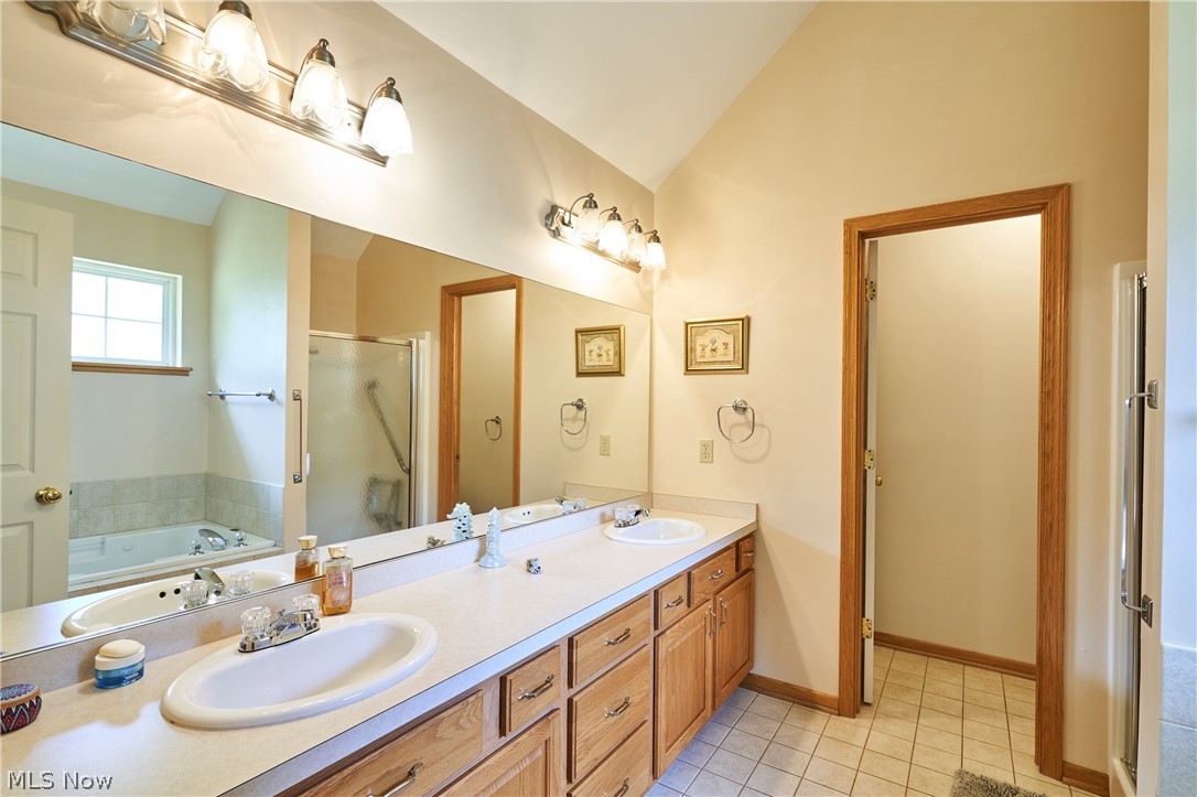 1963 Haines Road Madison, OH 44057 - Photo 12 of 34 Bathroom featuring a double vanity with light wood cabinetry, dual sinks, and an expansive mirror