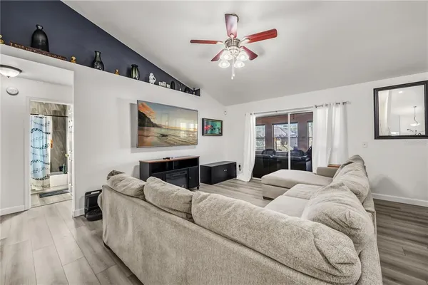 a living room with furniture a chandelier and a flat screen tv