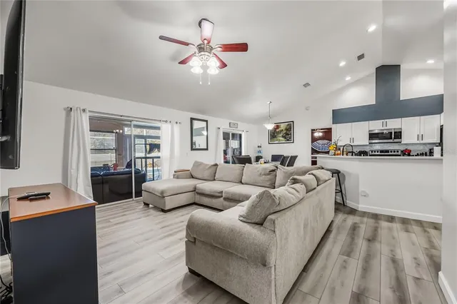 a living room with furniture kitchen and a wooden floor