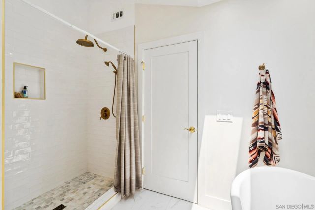 a bathroom with a double vanity sink mirror and shower
