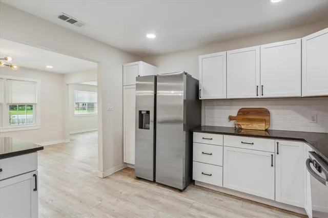 a kitchen with stainless steel appliances granite countertop a refrigerator and a stove top oven