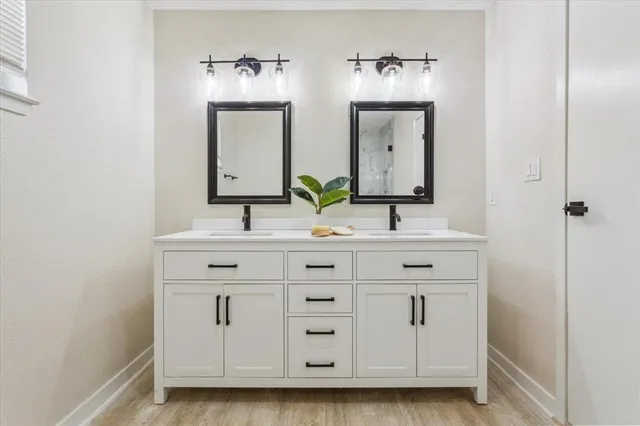 a bathroom with double vanity sinks and a mirror