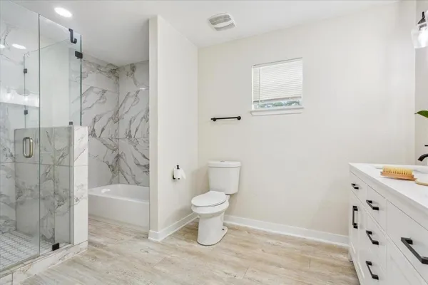 a bathroom with a sink a toilet and shower