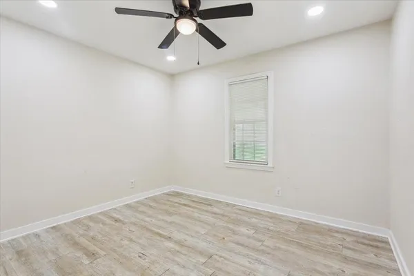 an empty room with a window and a fan