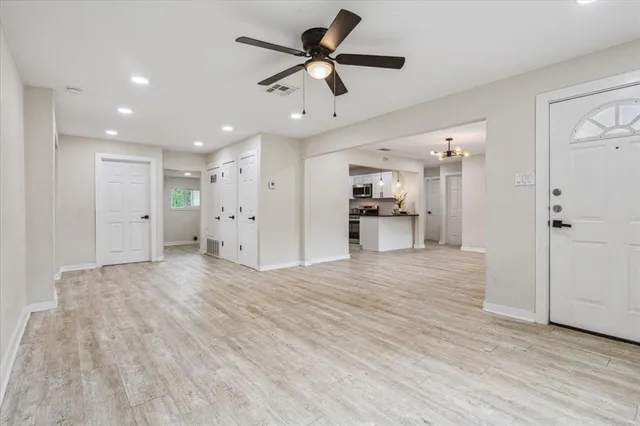 a view of an empty room and a kitchen