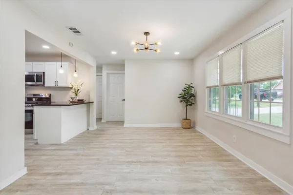 a view of an empty kitchen and kitchen with a sink wooden floor