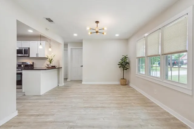 a view of an empty kitchen and kitchen with a sink wooden floor