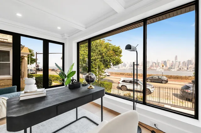 a view of a living room with furniture and floor to ceiling windows