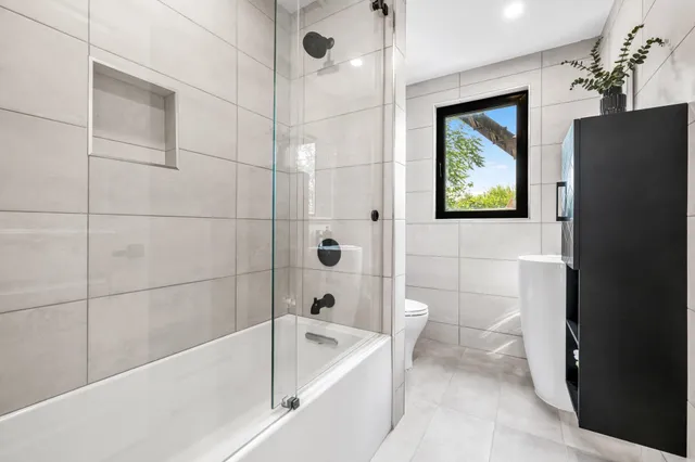 a bathroom with a toilet a sink and mirror