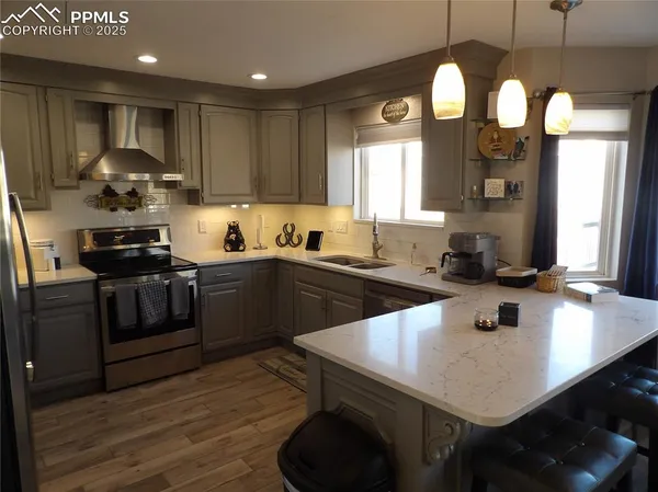 a kitchen with stainless steel appliances granite countertop a sink a stove and a refrigerator