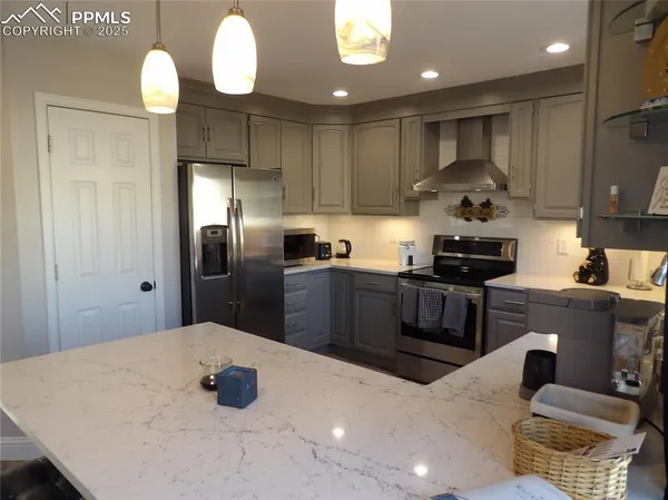 a kitchen with stainless steel appliances a dining table chairs and stove
