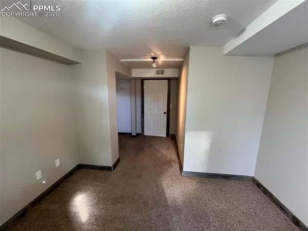 a living room with flat screen tv and a refrigerator