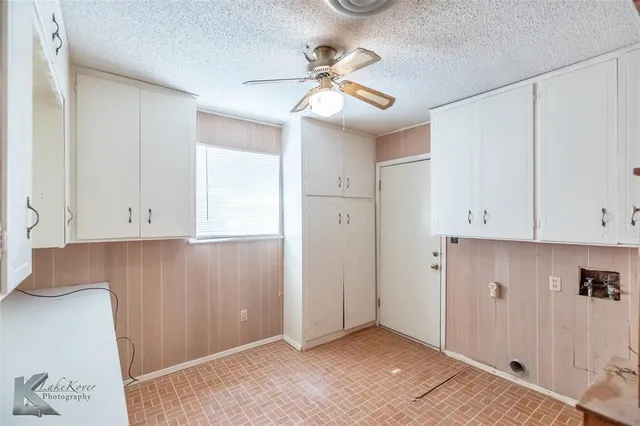 a view of an empty room and cabinet with hardwood floor