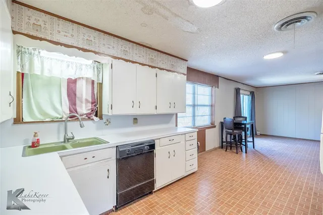 a kitchen with a table chairs sink and cabinets