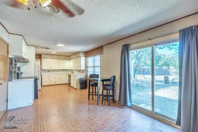 a open kitchen with white cabinets and stainless steel appliances