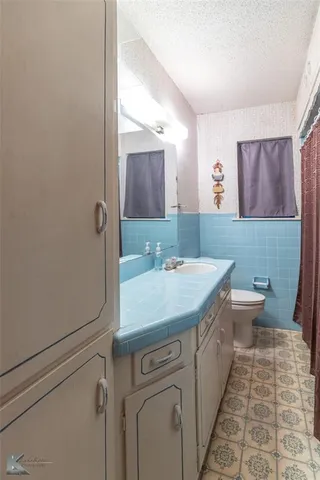 a bathroom with a sink a toilet and mirror