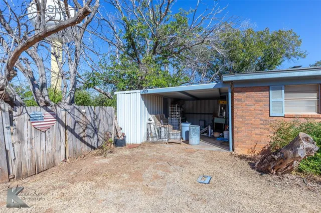 a view of house with a bench in patio