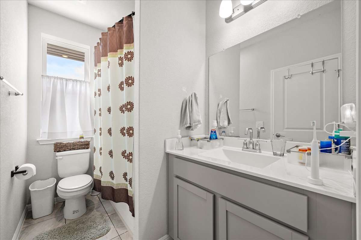 9015 Cattle Baron Path, Unit 1203 Austin, TX 78747 - Photo 20 of 23 Full bathroom featuring vanity and a textured wall