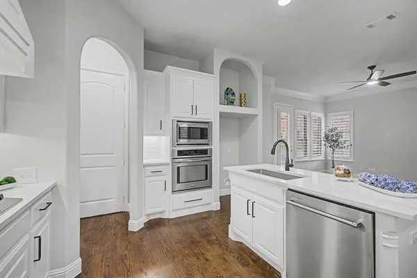 a kitchen with white cabinets and sink