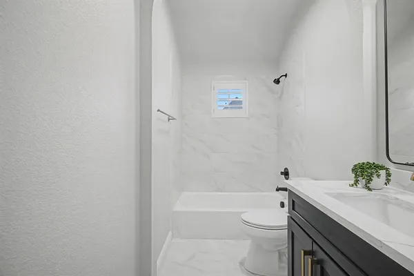 a bathroom with a granite countertop toilet a sink and bathtub