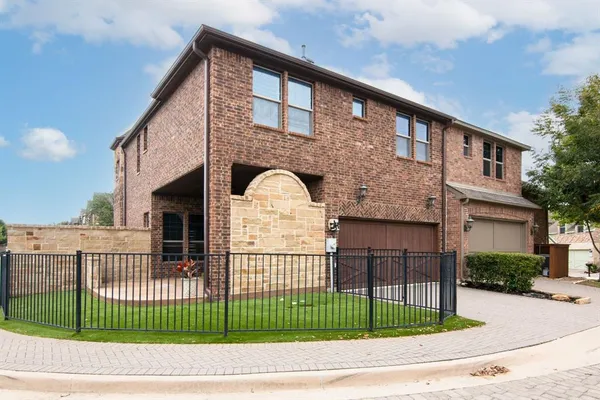 a view of a white house with a iron gate