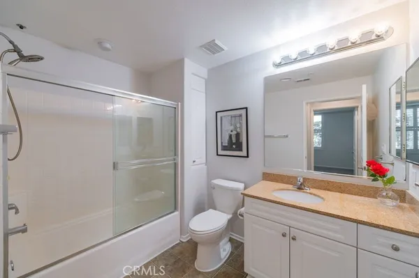 a bathroom with a granite countertop sink toilet and shower