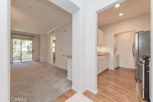 a view of a room with wooden floor and electronic appliances