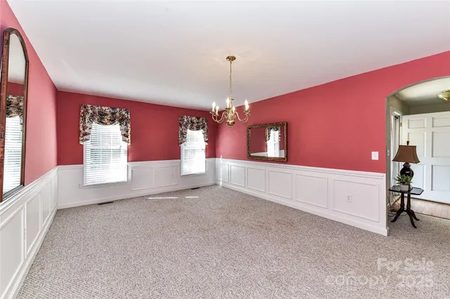 a view of a livingroom with a chandelier furniture and windows