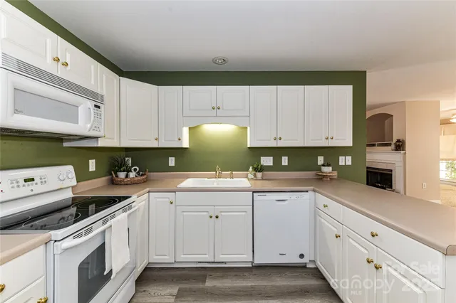 a kitchen with white cabinets and white appliances