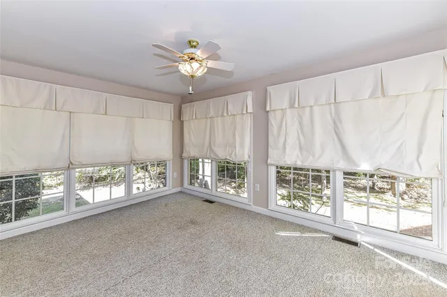a view of a livingroom with a chandelier fan and windows