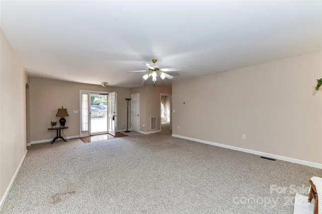 a view of a livingroom with a ceiling fan and window