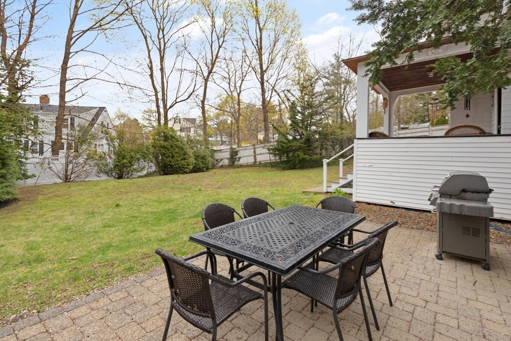 29 Station Street Sharon, MA 02067 - Photo 6 of 42 a view of a patio with table and chairs under an umbrella with large trees