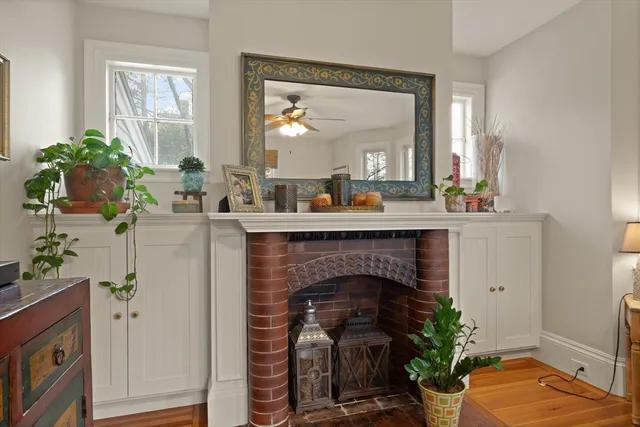 a living room with a fireplace furniture potted plant and a window