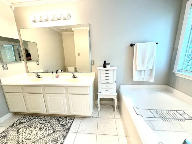 a spacious bathroom with a tub sink and a mirror