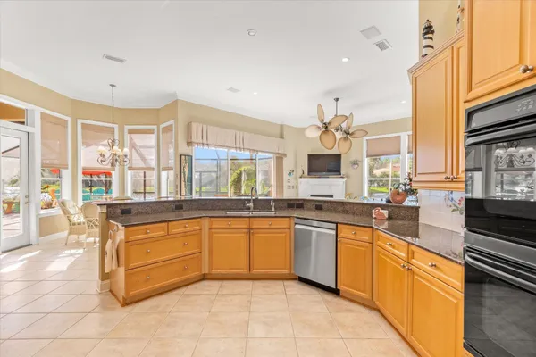 a large kitchen with kitchen island granite countertop a sink and dishwasher a oven with white cabinets