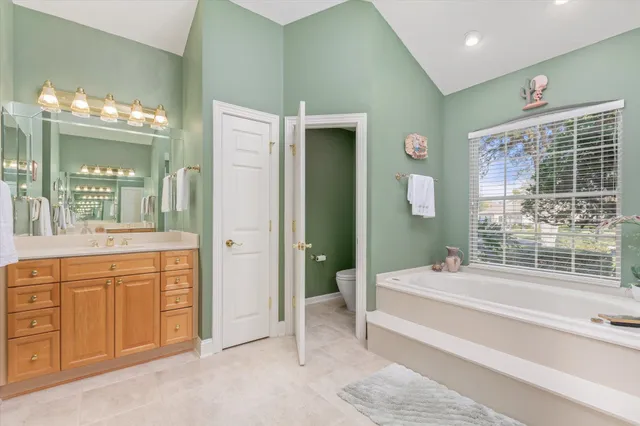 a spacious bathroom with a tub sink and mirror