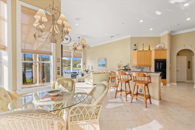 a living room with furniture a large window and chandelier