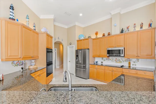 a kitchen with stainless steel appliances granite countertop a refrigerator and a sink