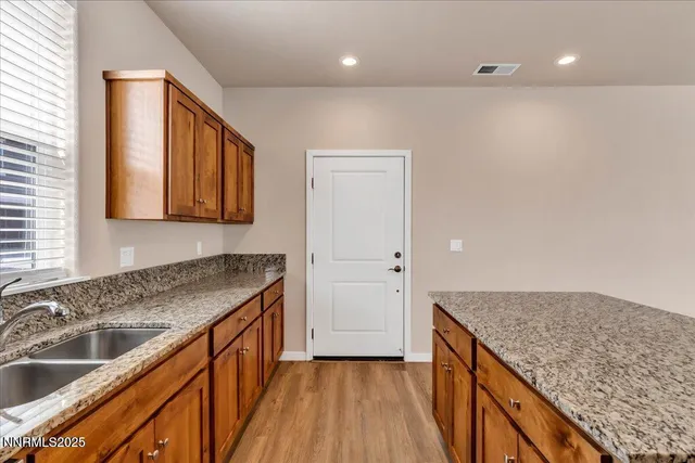 a kitchen with granite countertop cabinets sink and window