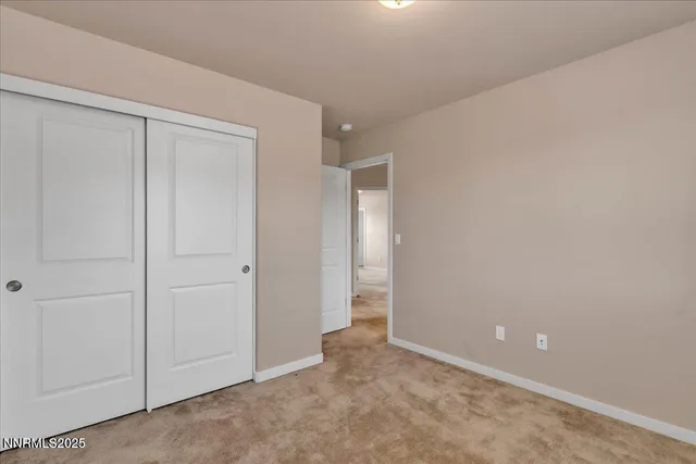 a view of a hallway with wooden floor and closet