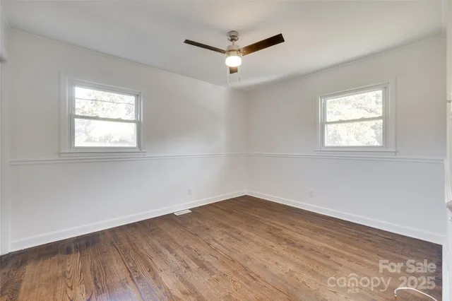 a view of a room with wooden floor and windows