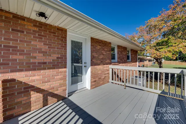 a view of a balcony with two chairs and a barbeque