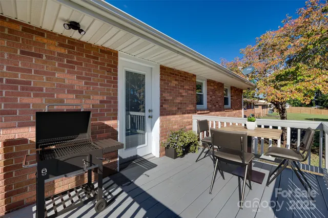 a view of a patio with a table and chairs next to a yard