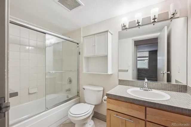 a bathroom with a sink toilet vanity and shower