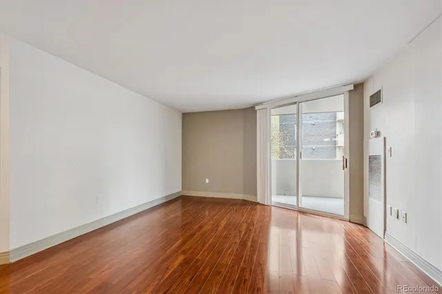 a view of an empty room with wooden floor