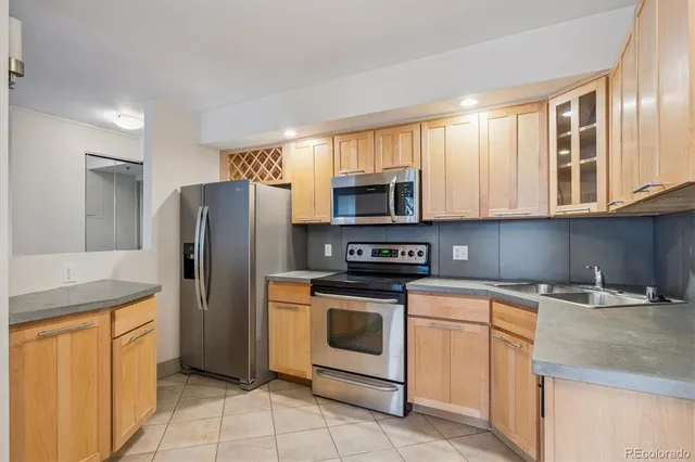 a kitchen with stainless steel appliances granite countertop a refrigerator stove and sink