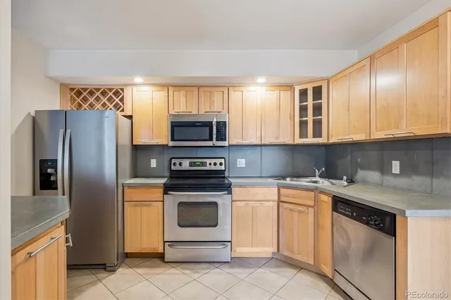 a kitchen with cabinets stainless steel appliances and sink