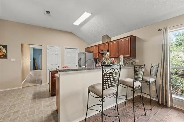 a kitchen with stainless steel appliances kitchen island granite countertop a refrigerator and a stove