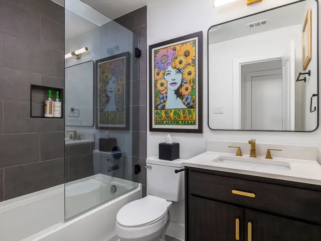 a bathroom with a sink a toilet and shower