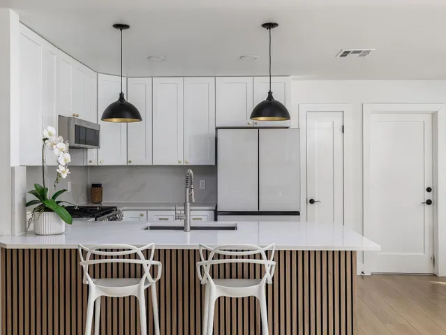 a kitchen with a sink a counter space appliances and cabinets